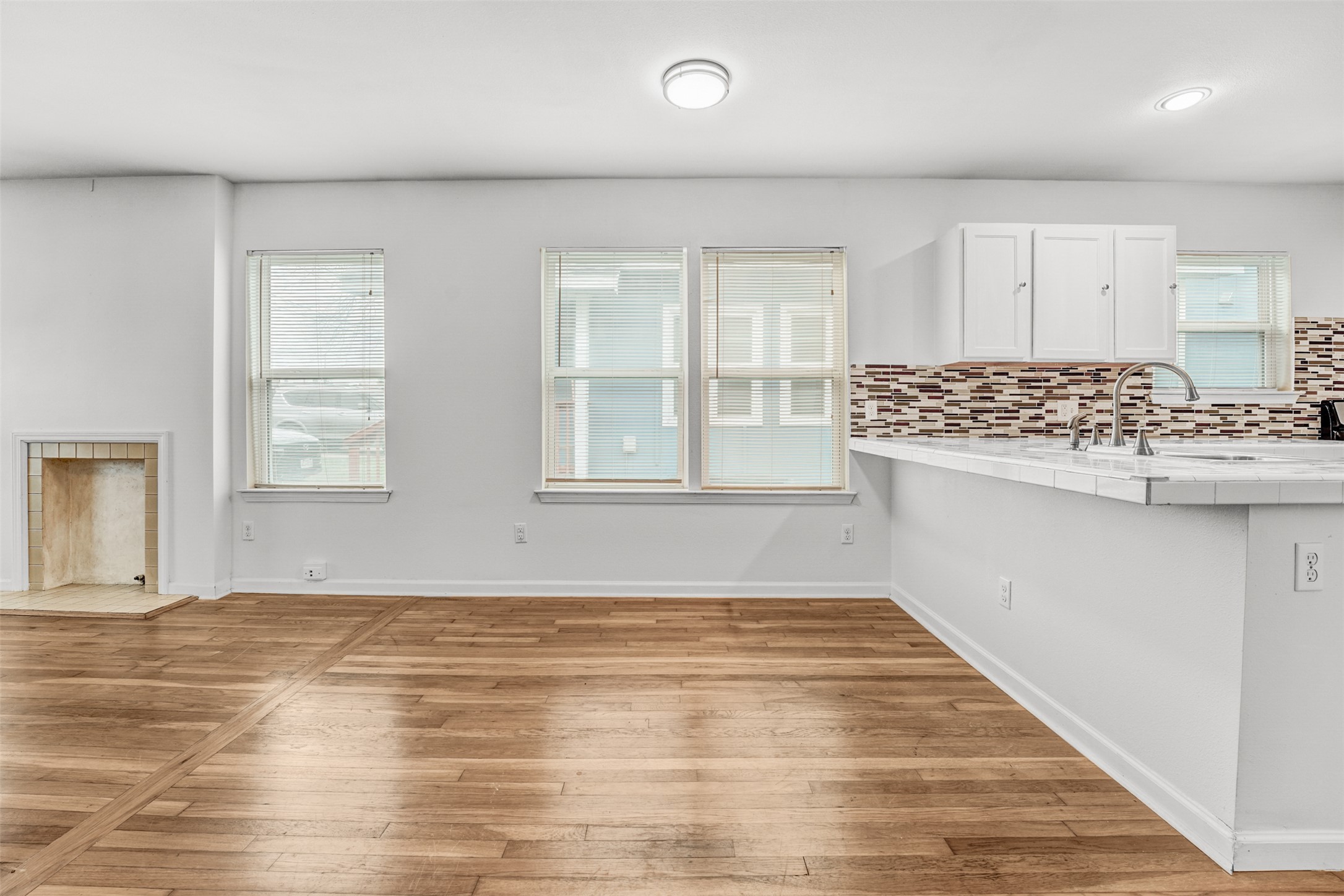 6906 Carver Avenue, Unit A Austin, TX 78752 - Photo 11 of 24 Unfurnished living room with light wood-style floors and a fireplace with raised hearth