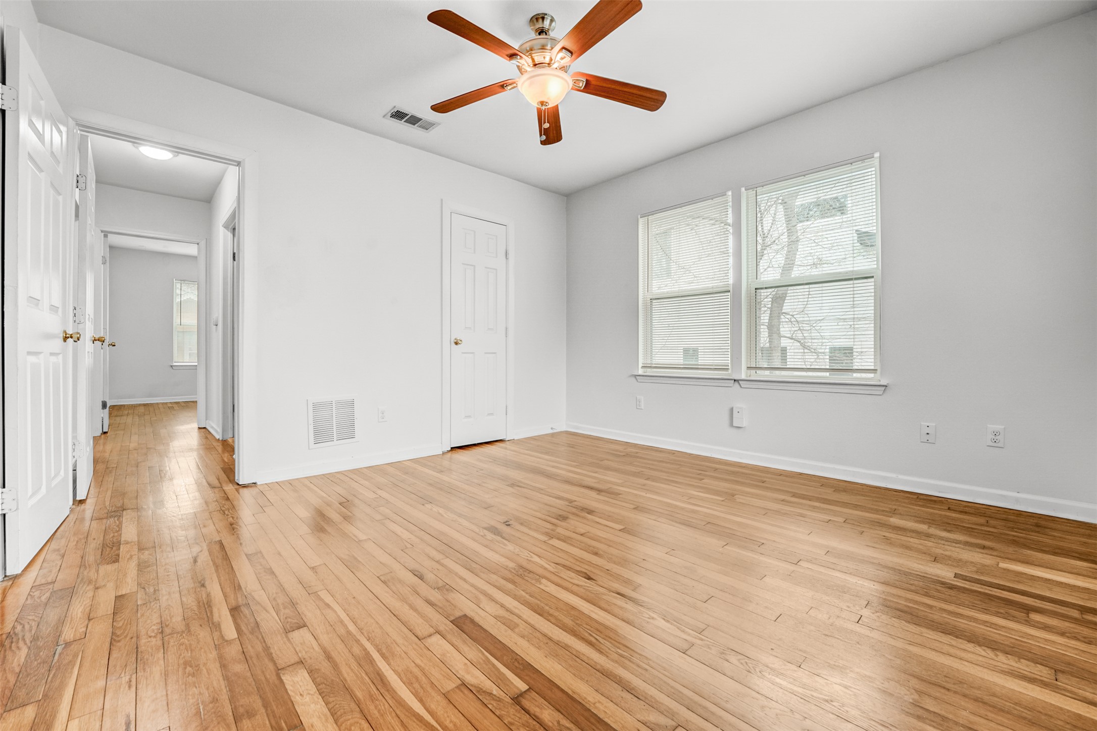 6906 Carver Avenue, Unit A Austin, TX 78752 - Photo 20 of 24 Unfurnished bedroom with light wood-style floors, a ceiling fan, and multiple windows
