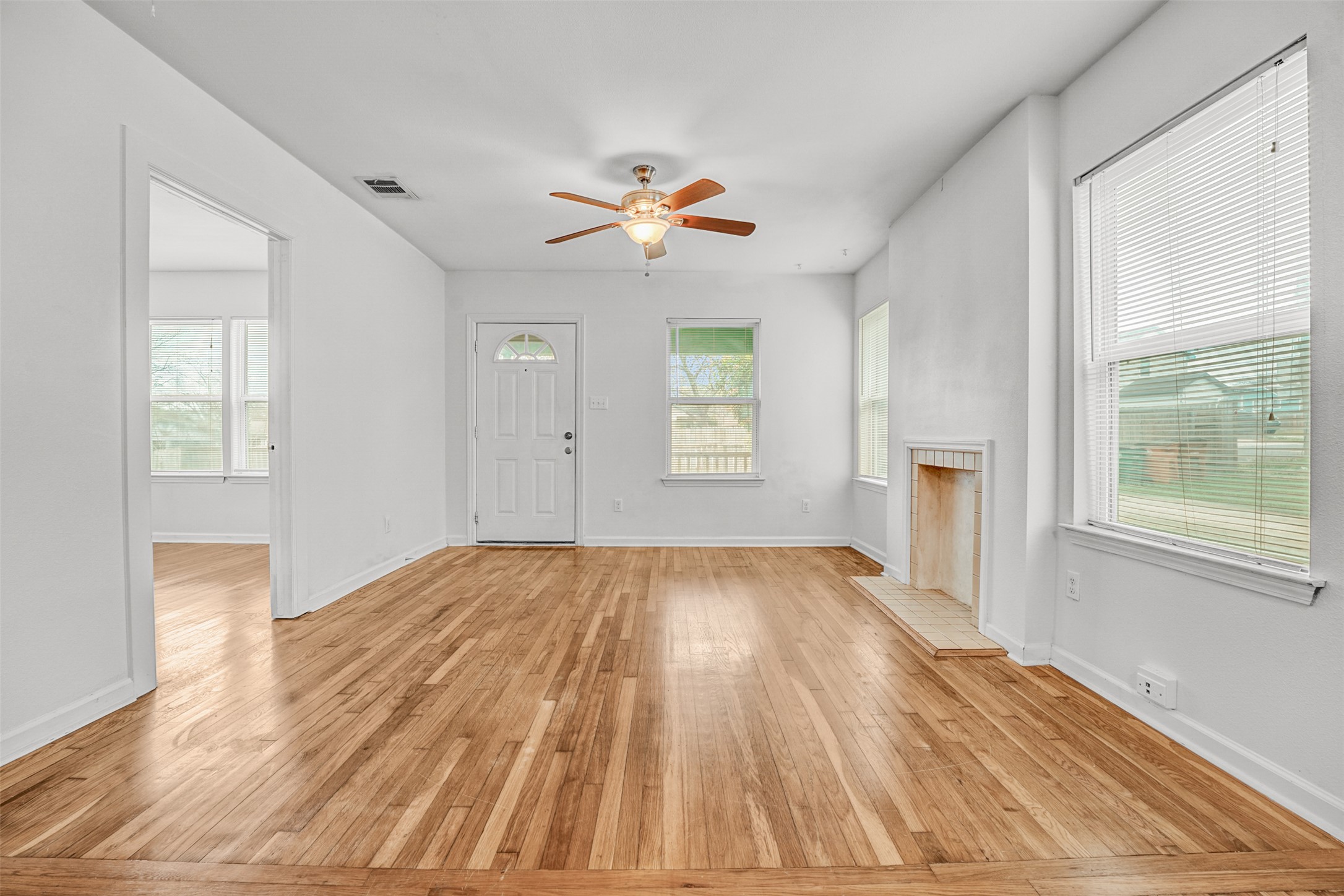 6906 Carver Avenue, Unit A Austin, TX 78752 - Photo 7 of 24 Unfurnished living room with light wood-type flooring, a ceiling fan, and a brick fireplace