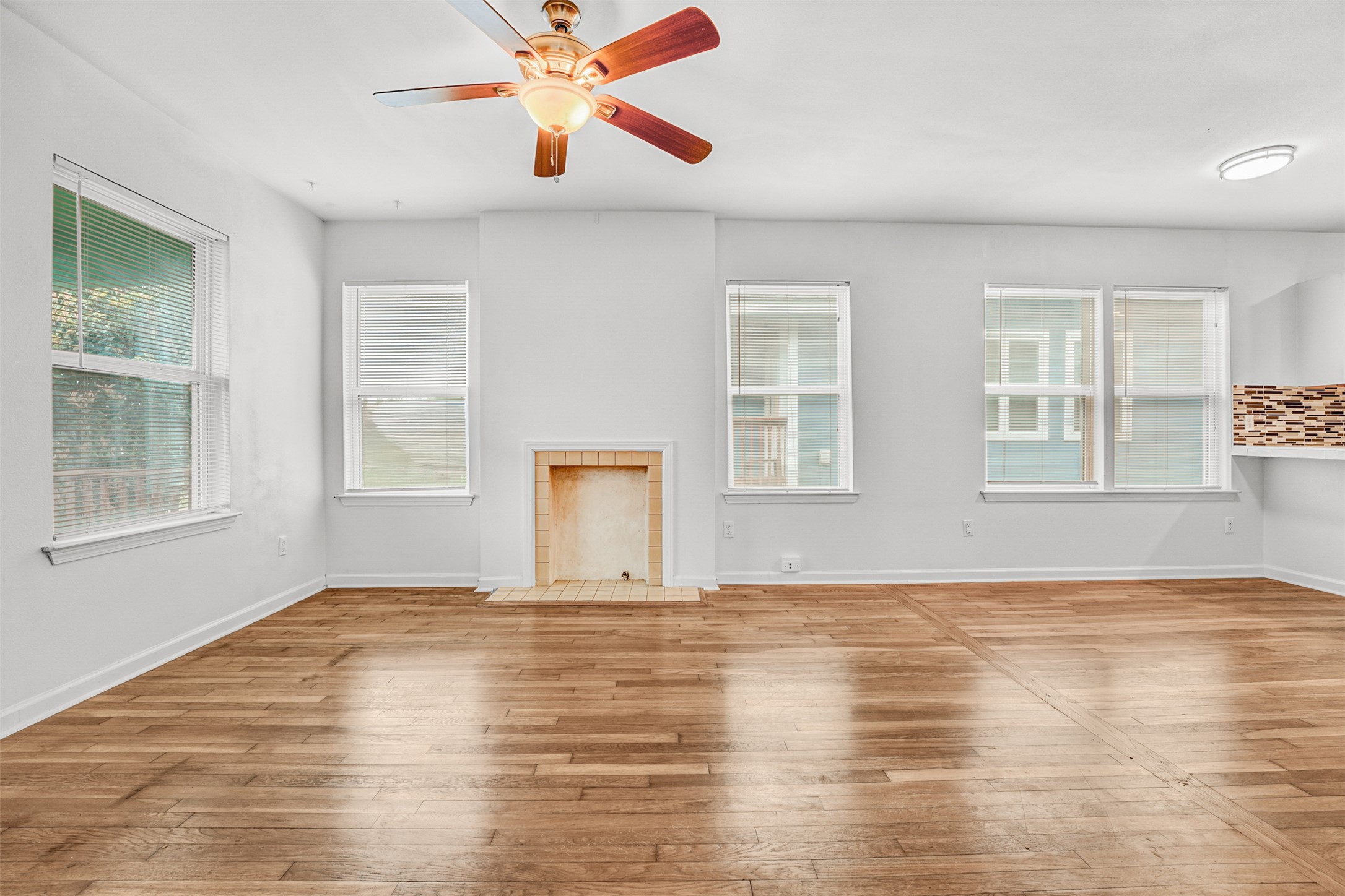 6906 Carver Avenue, Unit A Austin, TX 78752 - Photo 8 of 24 Unfurnished living room featuring a ceiling fan, hardwood / wood-style flooring, and a tiled fireplace