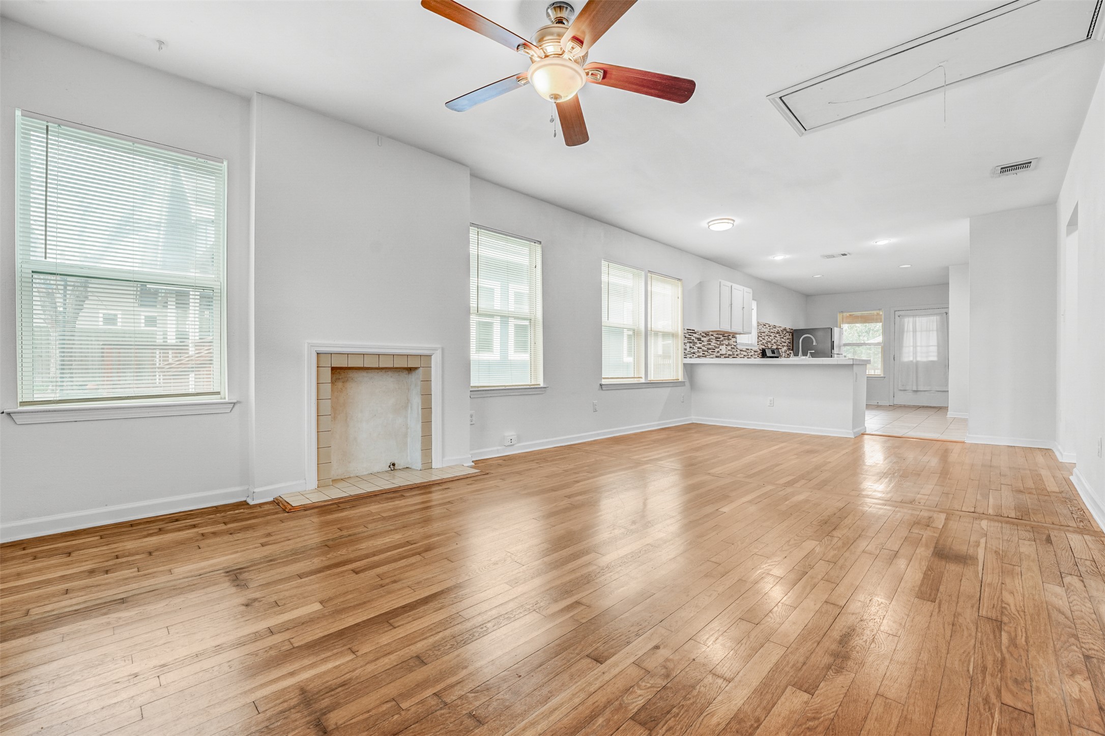 6906 Carver Avenue, Unit A Austin, TX 78752 - Photo 9 of 24 Unfurnished living room featuring ceiling fan, light wood-type flooring, and a fireplace