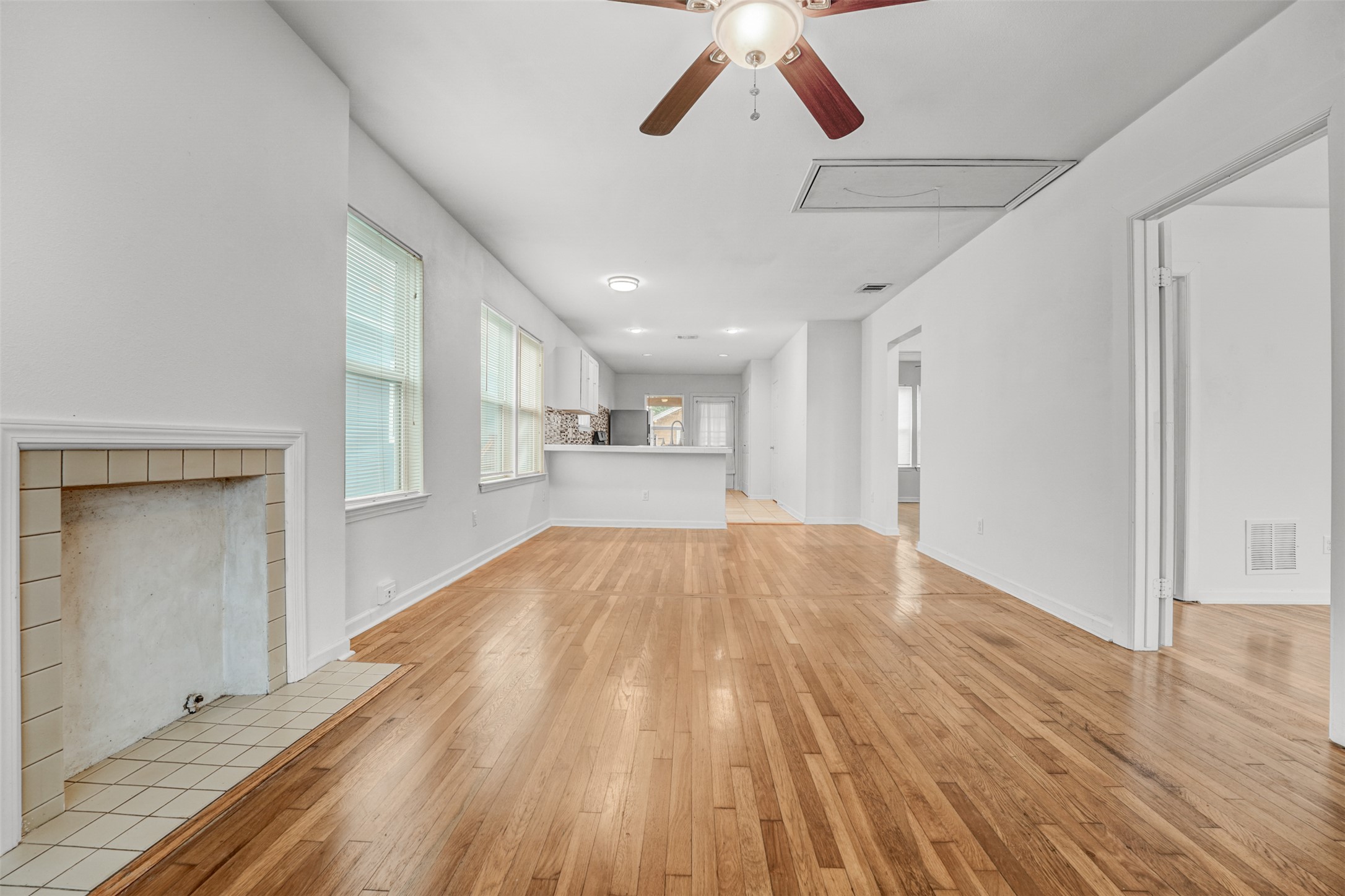 6906 Carver Avenue, Unit A Austin, TX 78752 - Photo 10 of 24 Unfurnished living room featuring a ceiling fan, light wood-style flooring, plenty of natural light, and a fireplace