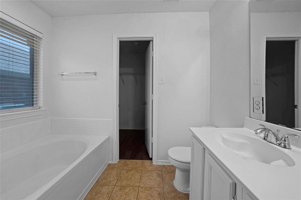 2910 Chisholm Trail Corinth, TX 76210 - Photo 18 of 30 a bathroom with a sink a toilet and shower