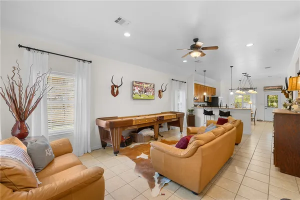 a living room with furniture ceiling fan and a window