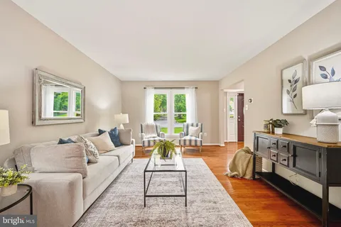 a living room with furniture wooden floor and a large window