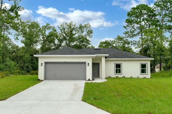 a front view of a house with a garden and yard