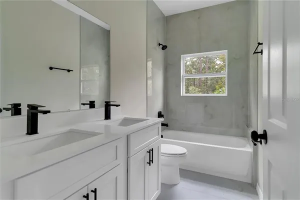 a bathroom with a tub sink toilet and a mirror