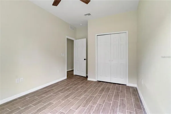 a view of an empty room with wooden floor