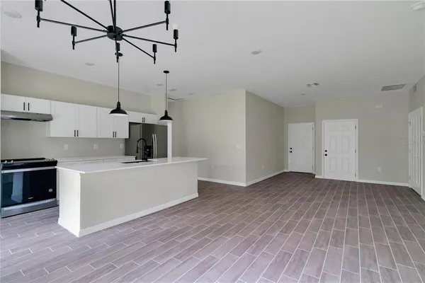 a view of a kitchen with wooden floor a sink and dishwasher