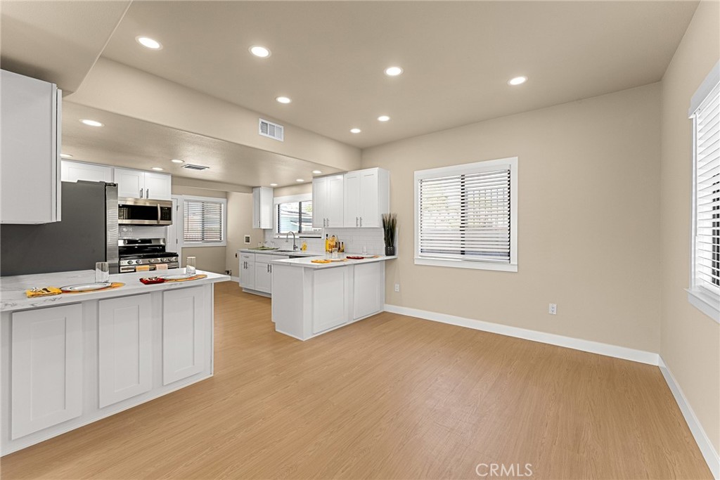2855 Mulberry Street Riverside, CA 92501 - Photo 12 of 43 a kitchen with stainless steel appliances kitchen island granite countertop a stove a sink a refrigerator and white cabinets with wooden floor
