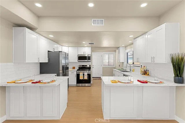 a kitchen with stainless steel appliances kitchen island refrigerator stove microwave and sink