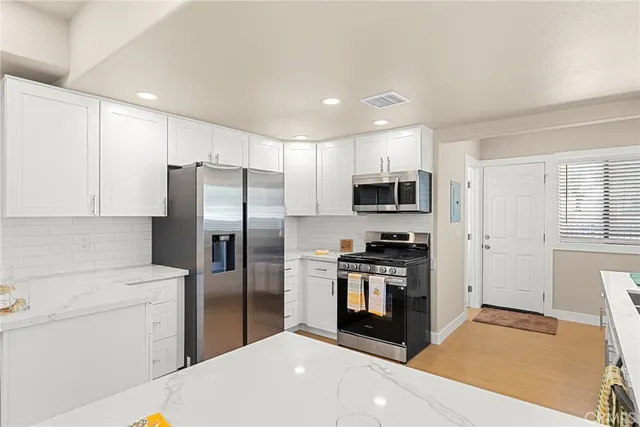 a kitchen with stainless steel appliances a refrigerator stove microwave and sink