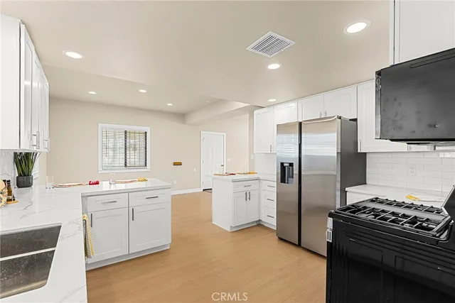 a kitchen with stainless steel appliances a refrigerator sink and stove