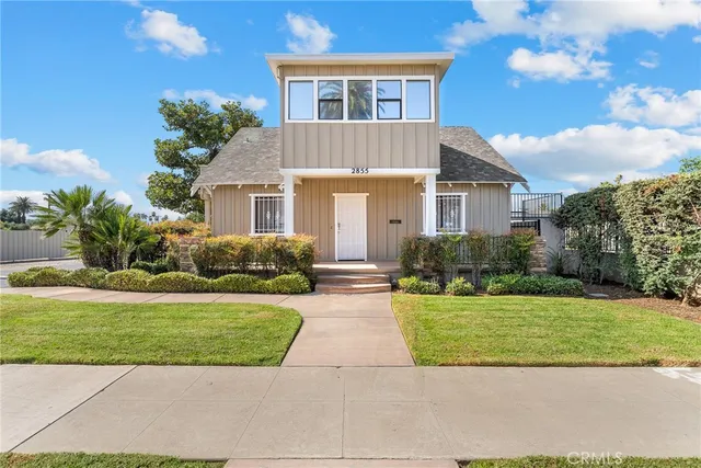 a front view of a house with a yard and potted plants
