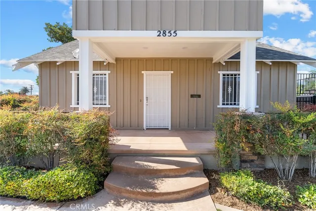 a front view of a house with plants