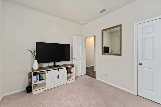 a living room with flat screen tv and gym equipment