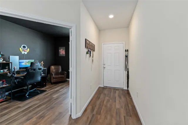 a view of a hallway with wooden floor and furniture