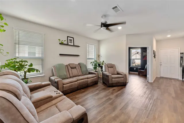 a living room with furniture and a wooden floor