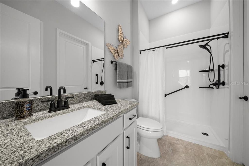 8750 Southwest 59th Ln Road Ocala, FL 34481 - Photo 12 of 41 a bathroom with a granite countertop sink a toilet and a mirror