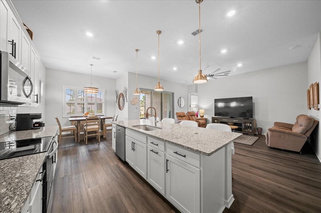 8750 Southwest 59th Ln Road Ocala, FL 34481 - Photo 26 of 41 a open kitchen with stainless steel appliances granite countertop a lot of counter space and wooden floor