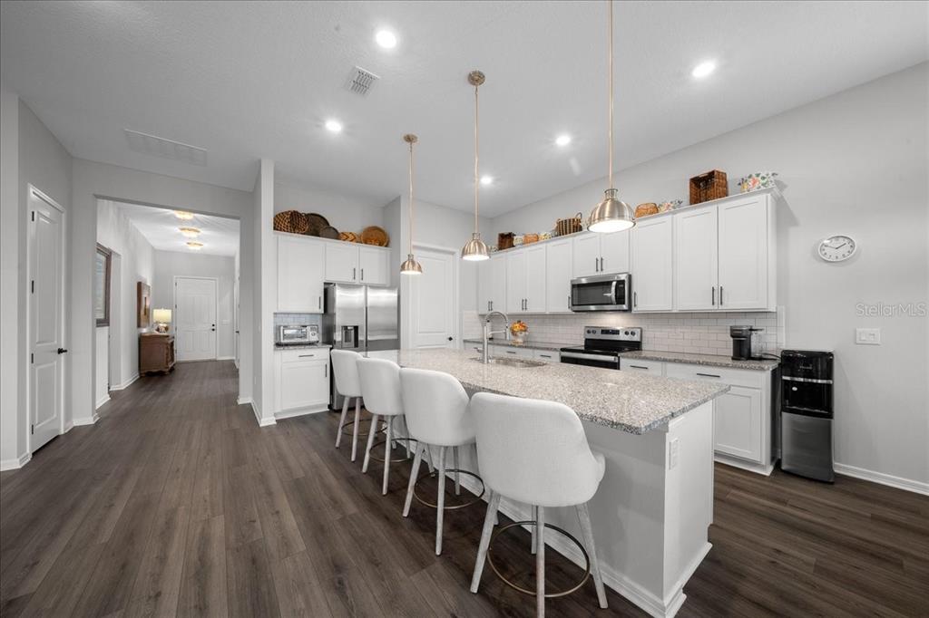 8750 Southwest 59th Ln Road Ocala, FL 34481 - Photo 32 of 41 a large kitchen with cabinets chairs and wooden floor