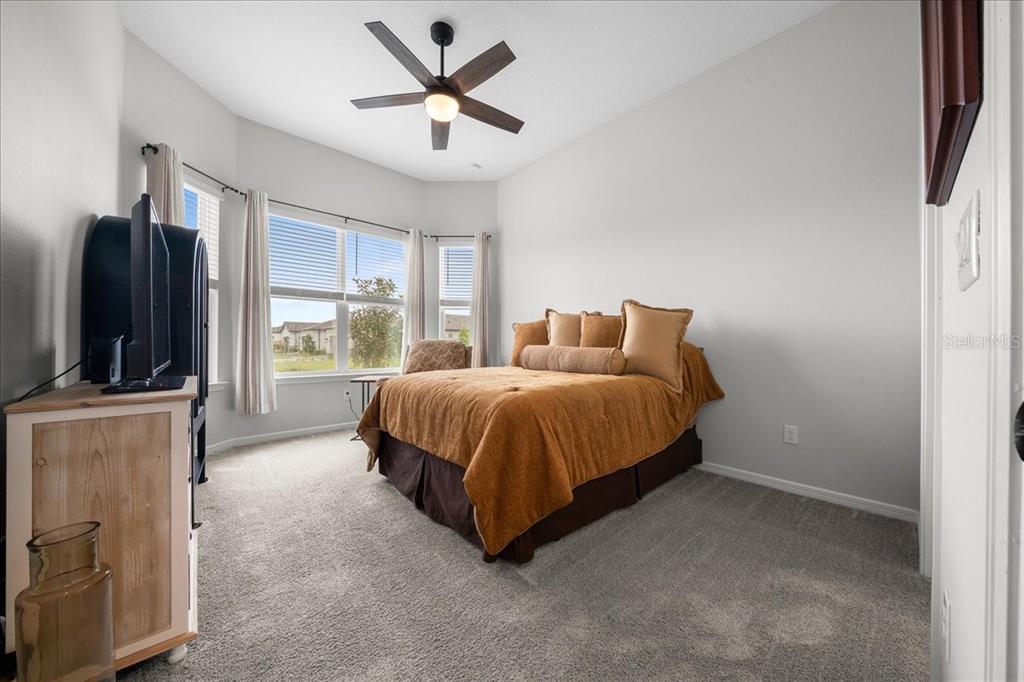 8750 Southwest 59th Ln Road Ocala, FL 34481 - Photo 9 of 41 a spacious bedroom with a bed flat screen tv and a large window
