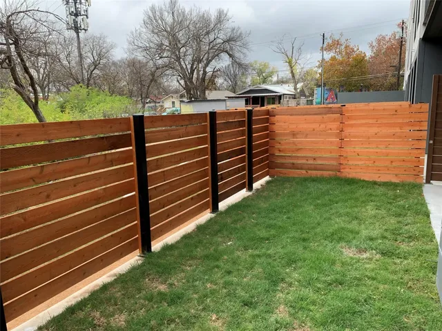 a view of a yard with wooden fence