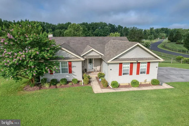 a front view of a house with a yard and trees