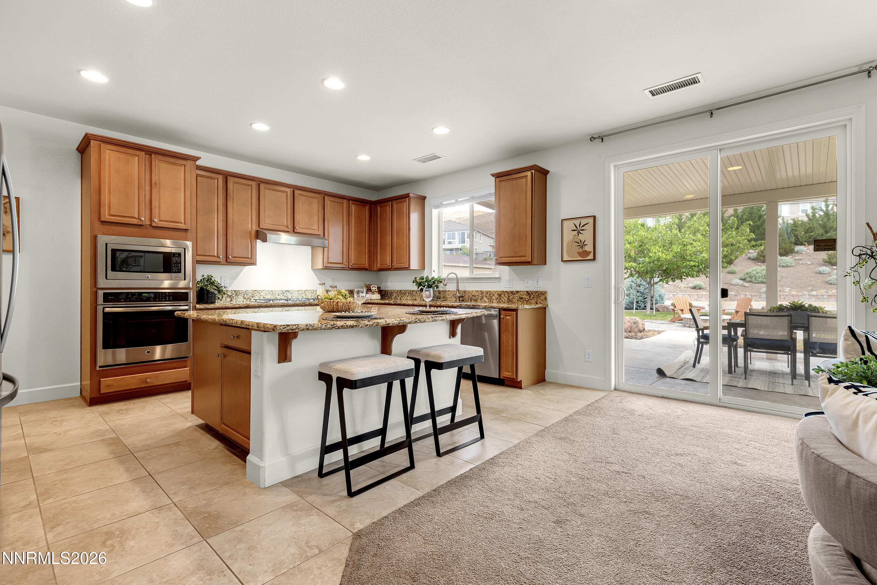 10150 Barrel Racer Drive Reno, NV 89521 - Photo 16 of 64 a kitchen with stainless steel appliances granite countertop a stove a sink a refrigerator and a microwave