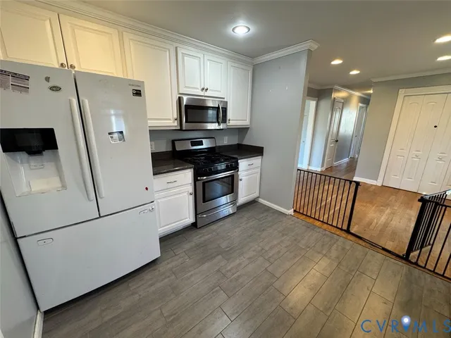a kitchen with stainless steel appliances a refrigerator a stove a microwave and cabinets