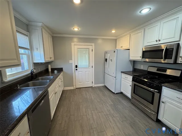a kitchen with stainless steel appliances granite countertop a stove a sink and a refrigerator