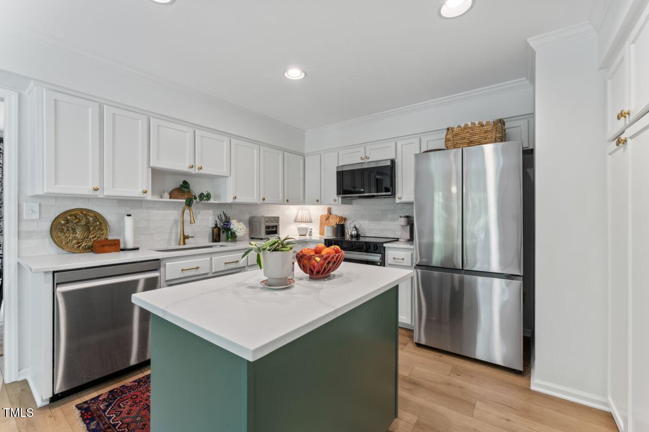 10817 Brass Kettle Road Raleigh, NC 27614 - Photo 17 of 55 a kitchen with stainless steel appliances a stove refrigerator sink and cabinets