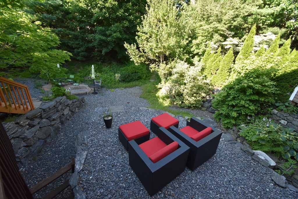 33 Deer Path, Unit 33 Hudson, MA 01749 - Photo 3 of 24 a wooden bench sitting in the middle of a garden