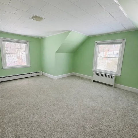 an empty room with a window and a fireplace