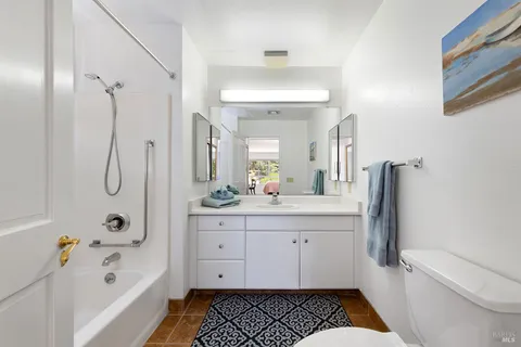 a bathroom with a tub sink toilet and a mirror