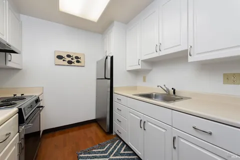 a kitchen with stainless steel appliances granite countertop white cabinets and a stove