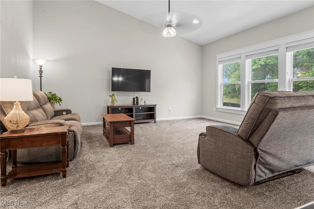 6824 Hatching Way North Ridgeville, OH 44039 - Photo 9 of 42 Living room featuring ceiling fan, a wealth of natural light, vaulted ceiling, and carpet flooring