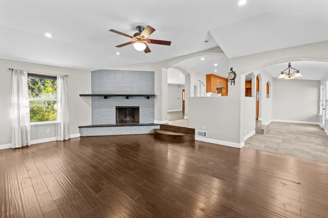 a view of empty room with wooden floor and window