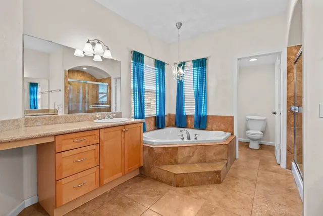 a spacious bathroom with a tub sink and mirror