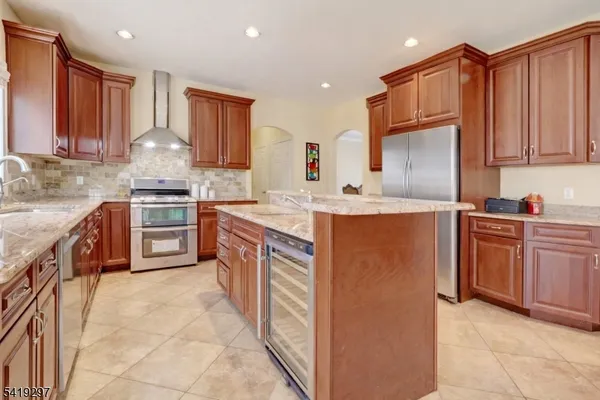 a kitchen with stainless steel appliances granite countertop a stove a sink and a refrigerator