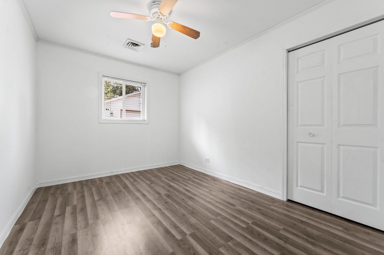 134 Monee Road Park Forest, IL 60466 - Photo 14 of 23 an empty room with wooden floor chandelier fan and windows