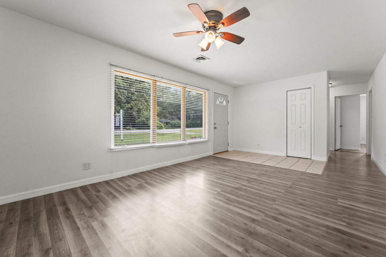 134 Monee Road Park Forest, IL 60466 - Photo 3 of 23 a view of an empty room with a window and wooden floor