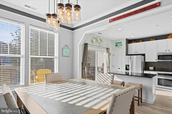 a large white kitchen with stainless steel appliances granite countertop a stove and a cabinets