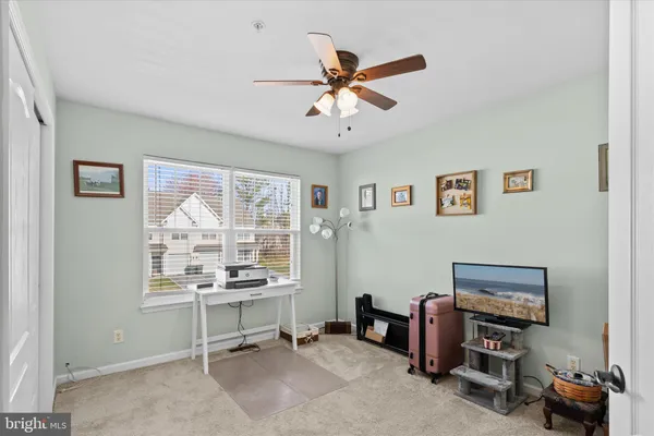 a room with chandelier fan and windows