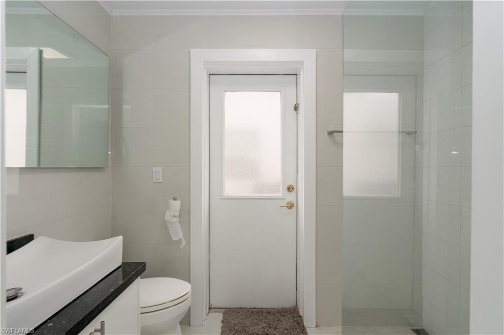 8271 Laurel Lakes Way Naples, FL 34119 - Photo 15 of 36 a bathroom with a toilet a sink and shower