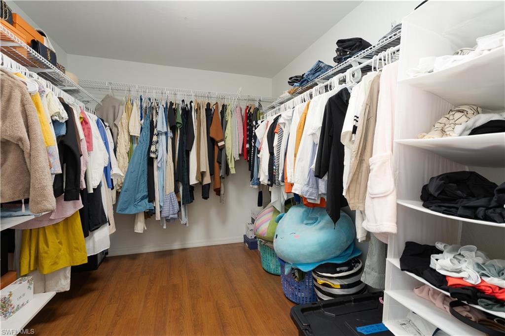 8271 Laurel Lakes Way Naples, FL 34119 - Photo 18 of 36 a view of walk in closet with clothes and shoes