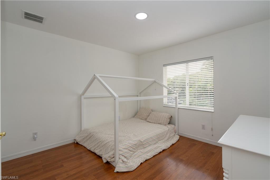 8271 Laurel Lakes Way Naples, FL 34119 - Photo 21 of 36 a view of a room with wooden floor and window