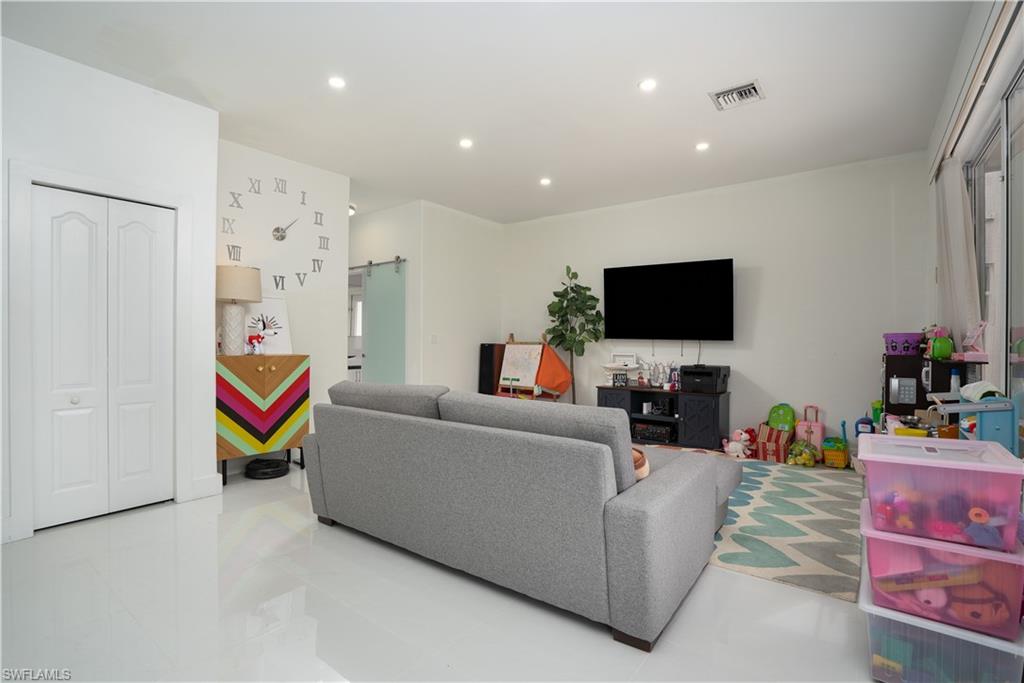 8271 Laurel Lakes Way Naples, FL 34119 - Photo 4 of 36 a living room with furniture and a flat screen tv
