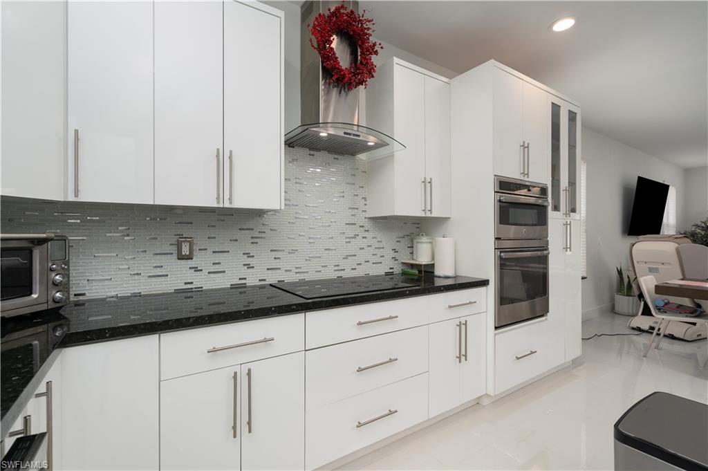 8271 Laurel Lakes Way Naples, FL 34119 - Photo 9 of 36 a kitchen with stainless steel appliances granite countertop a sink a stove and cabinets