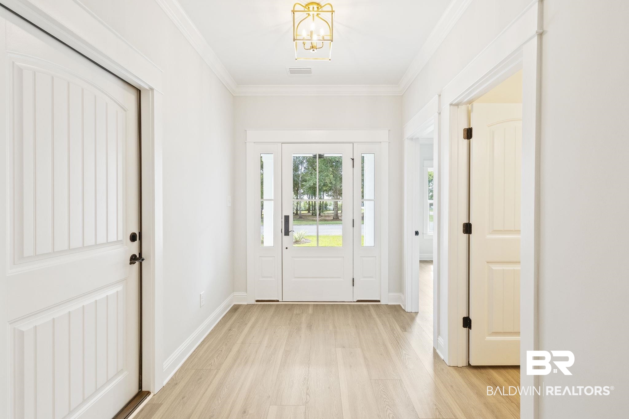 12130 Reunion Place Foley, AL 36535 - Photo 7 of 42 Entryway with crown molding, light hardwood / wood-style flooring, and a notable chandelier